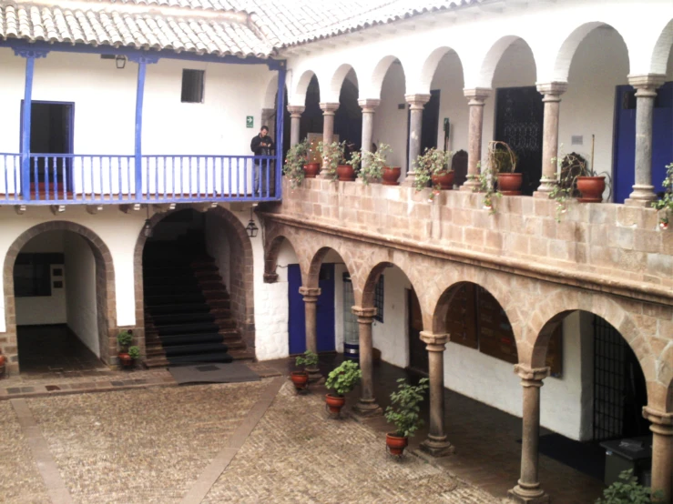 a large, white and blue building with arches and flower pots