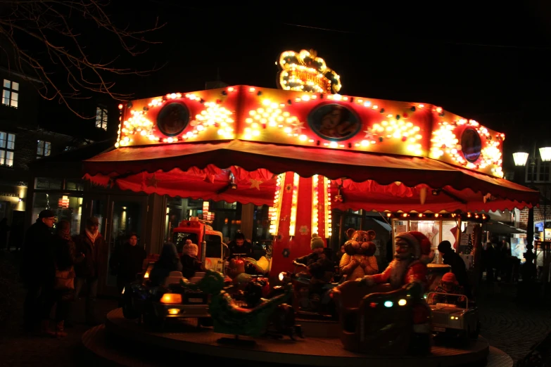 a carousel at night, with people around it