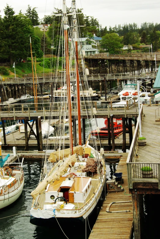 two sailboats are docked near a wooden dock