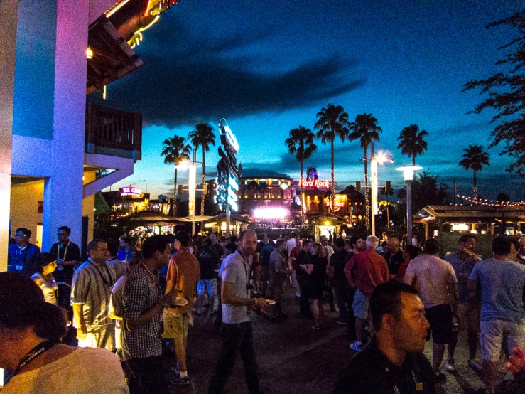 a crowded street area at dusk with people walking