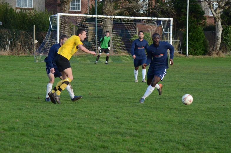 group of men on soccer field playing a game of soccer