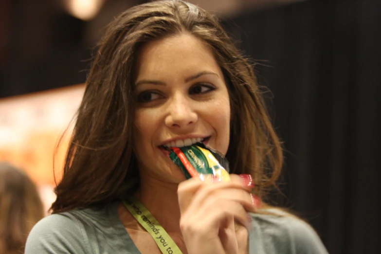 a girl holding several wrapped toothbrushes to her mouth