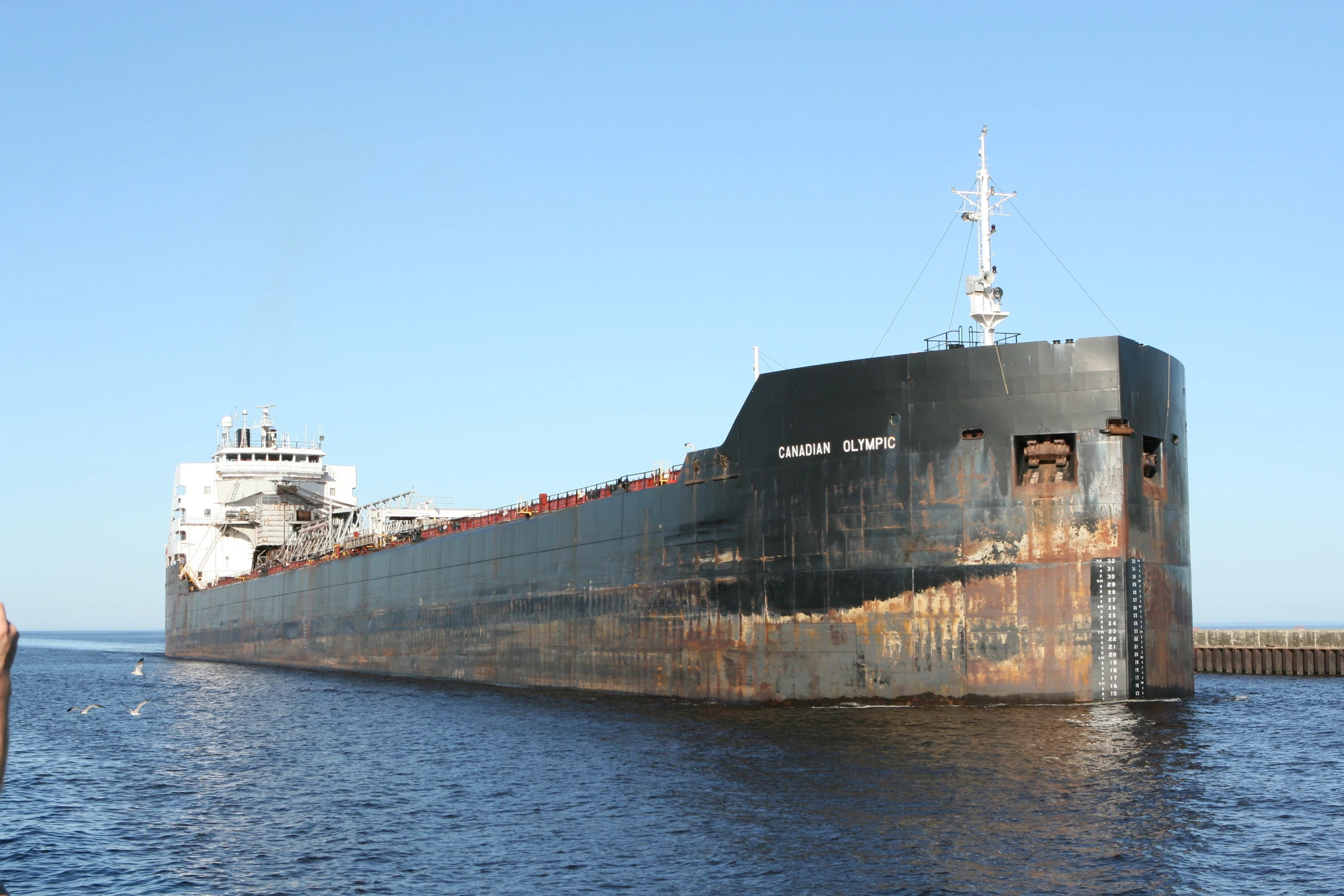 large rusty ship sitting in the ocean next to another boat