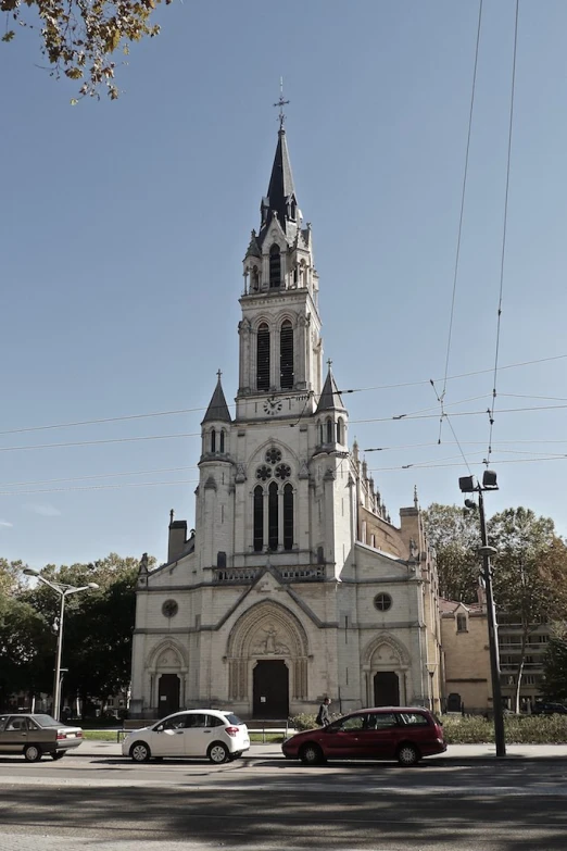 a large church has two towers with cars in front