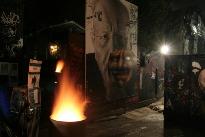 a lit fire next to several large posters