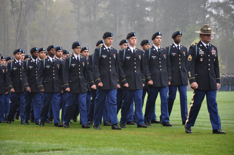 soldiers are wearing uniform as they march across the field