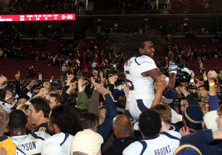 a crowd holds up and high fives for the basketball team