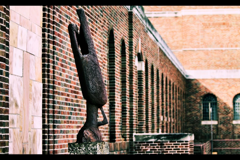 a wooden object hanging on a brick wall near a building