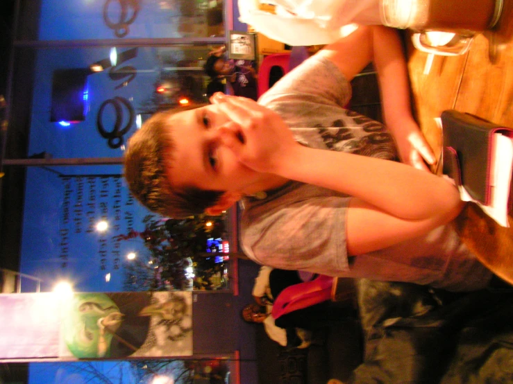 a boy sitting at a table with a cup of coffee in front of him