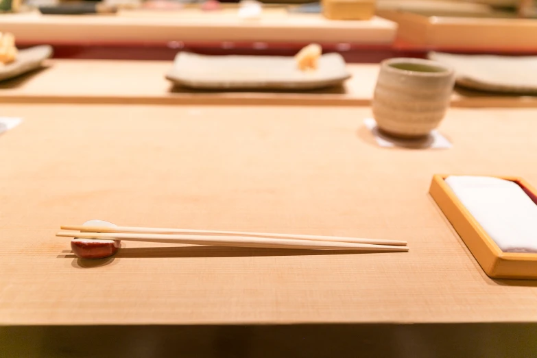 two chopsticks resting on some chopsticks in front of some sushi
