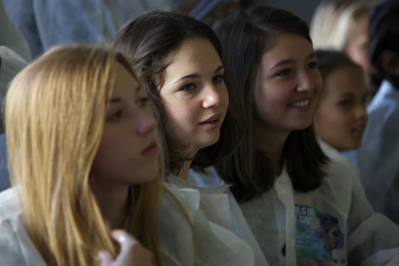 several girls are waiting with one boy looking down