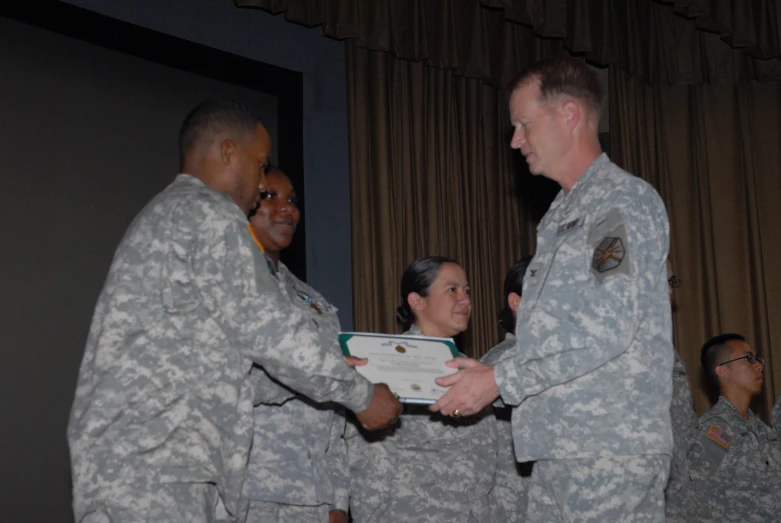 military personnel from two sides shaking hands and smiling