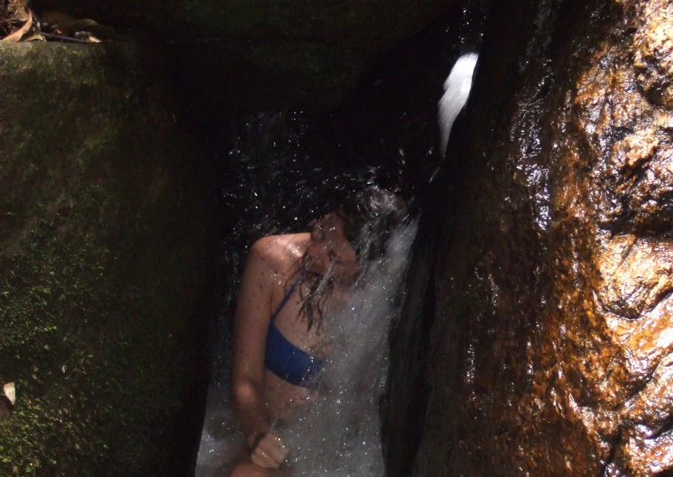 a woman in a bathing suit is tubling down a waterfall