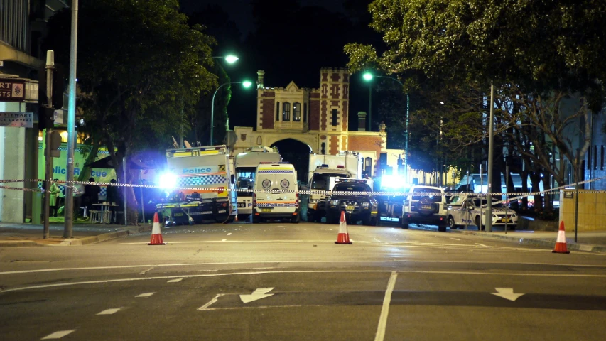 a city street with emergency vehicles on it at night