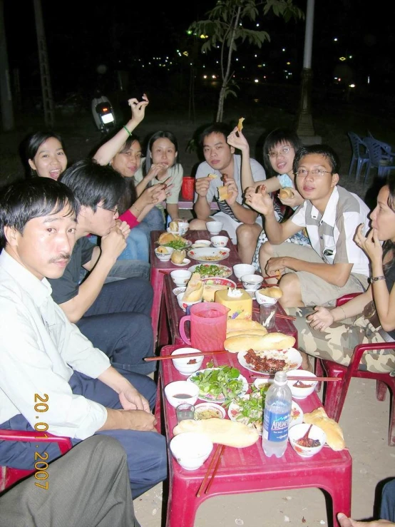 group of people at table outside at night time