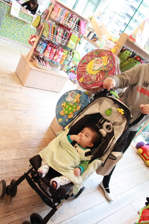 a baby in a stroller in front of a baby store