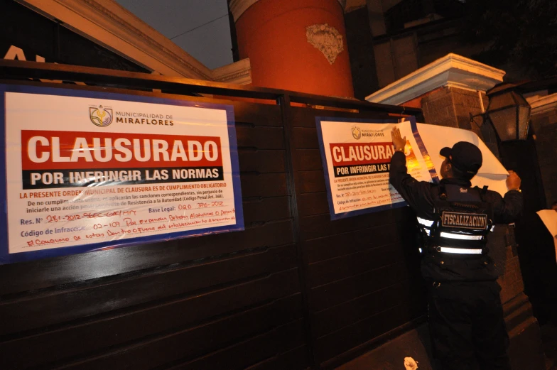 two men outside of a building holding signs