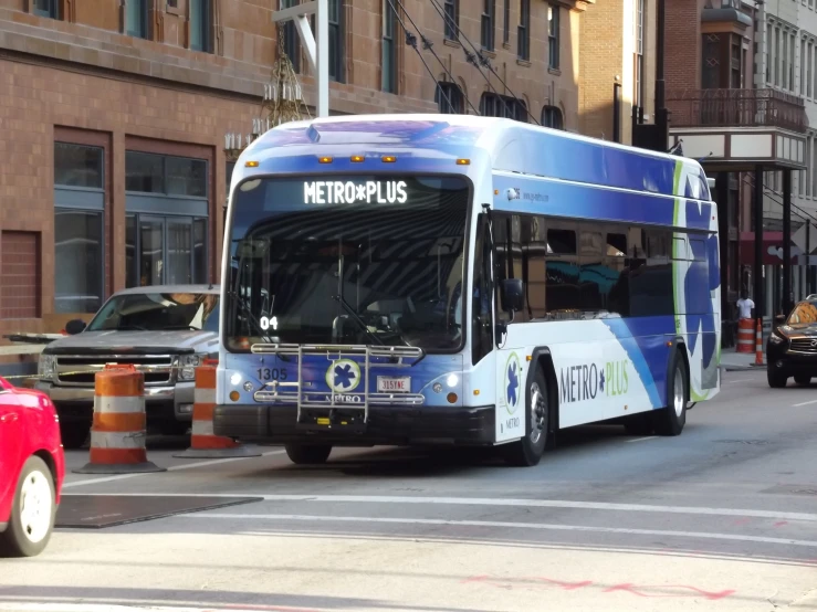 a blue and white bus driving down a road