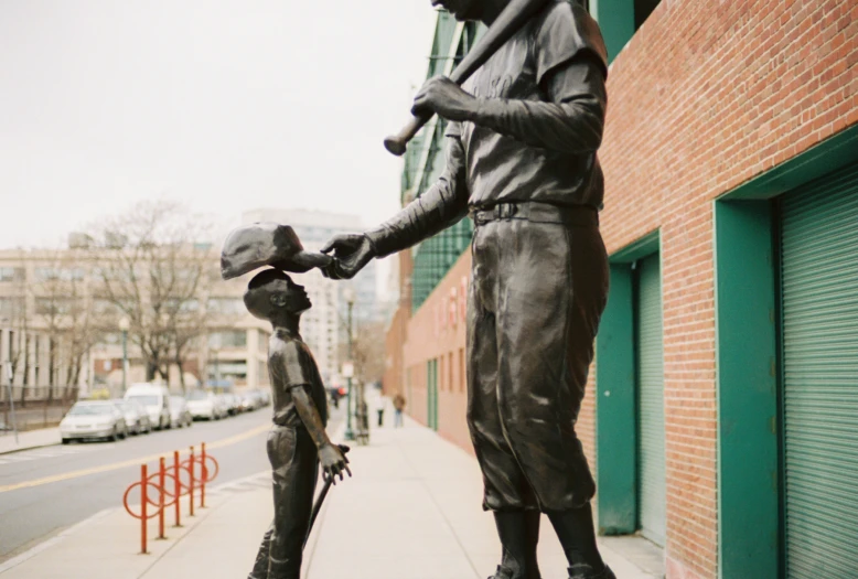 two small statues holding hands as they are on the side of a building