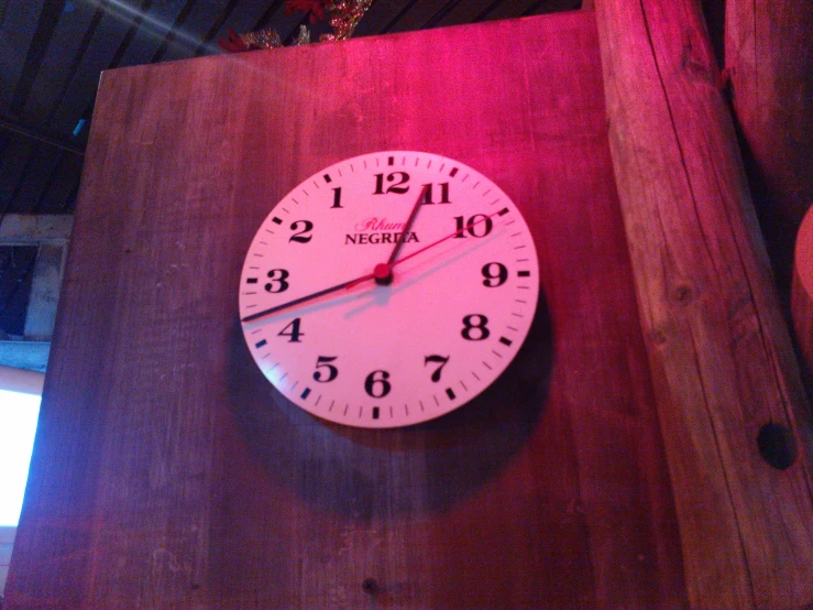 the white clock on the wood is telling to go 3 00
