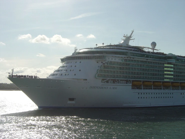 a cruise ship sailing in the water with people standing on the top