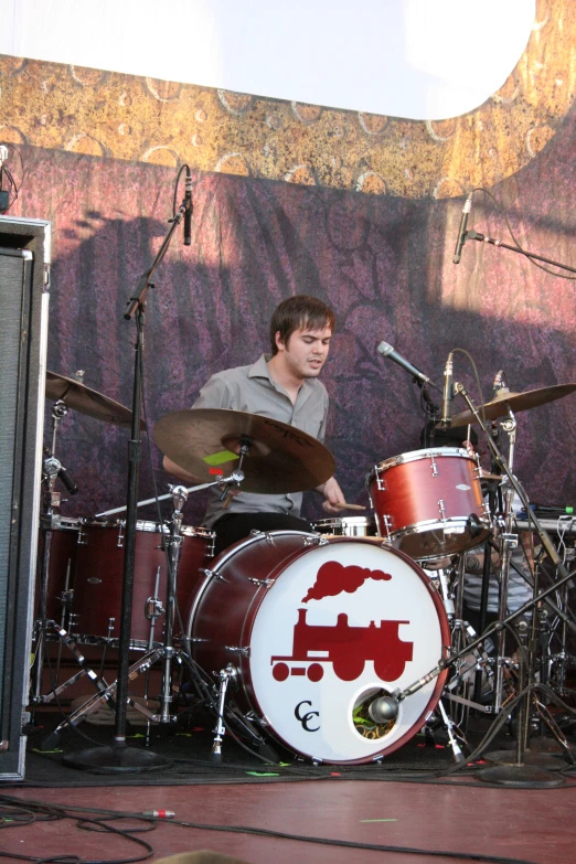 a man that is sitting on a drumset