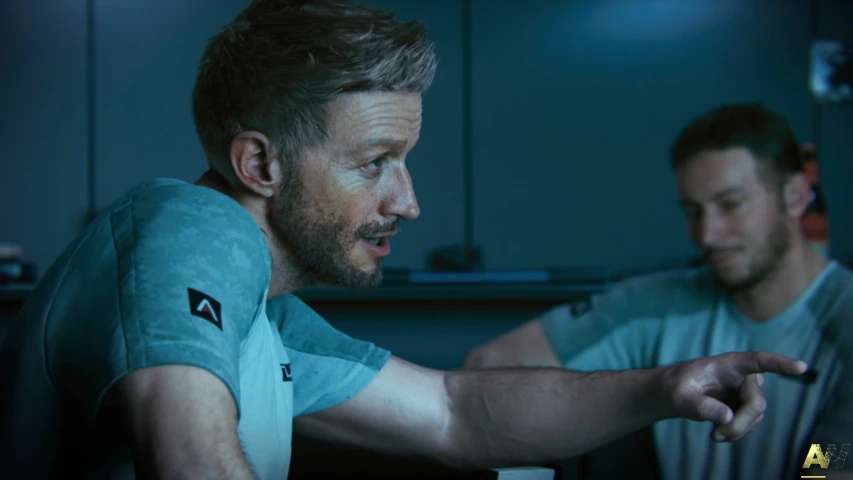 two men in blue shirts on a dark background