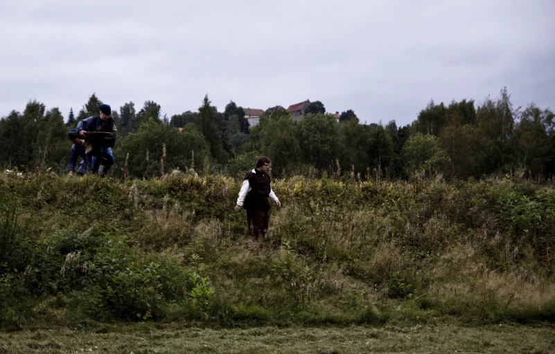 a small group of people are standing in a field