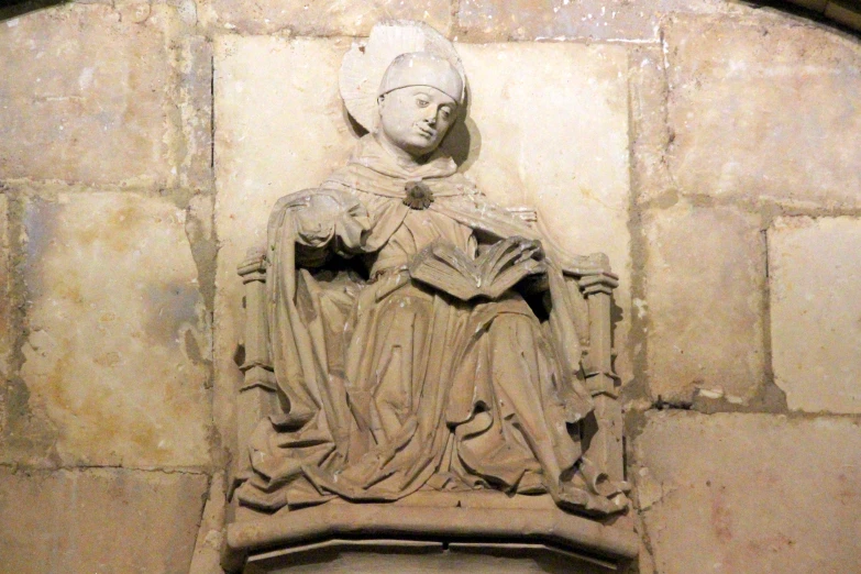 the head and body of an old statue is shown against a brick wall