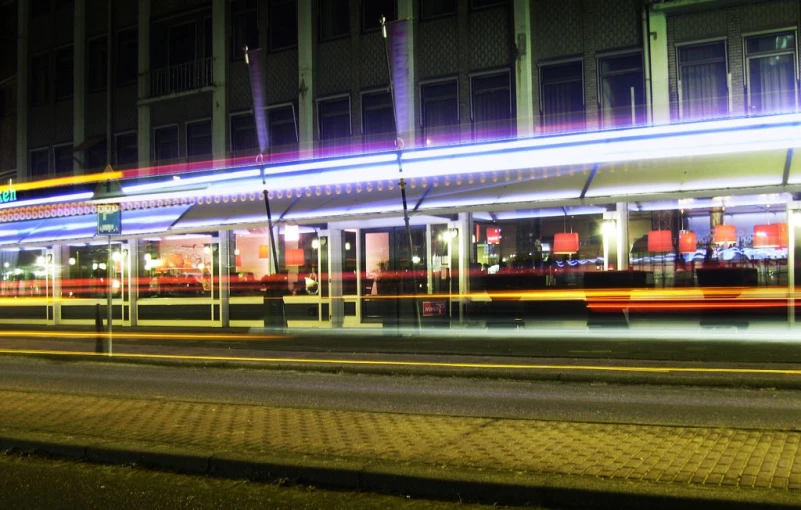 a bus is moving past an illuminated city street