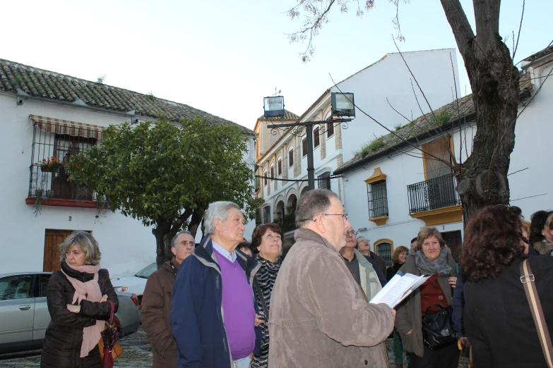 people standing in a line on a street with one man facing the camera