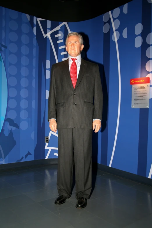 man in suit standing in front of large wall