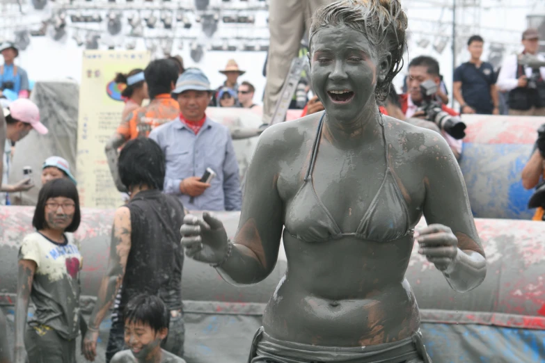 a woman in grey mud and other people