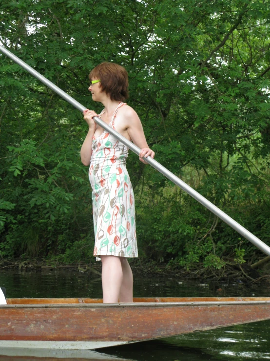 a woman in a pretty dress on top of a boat