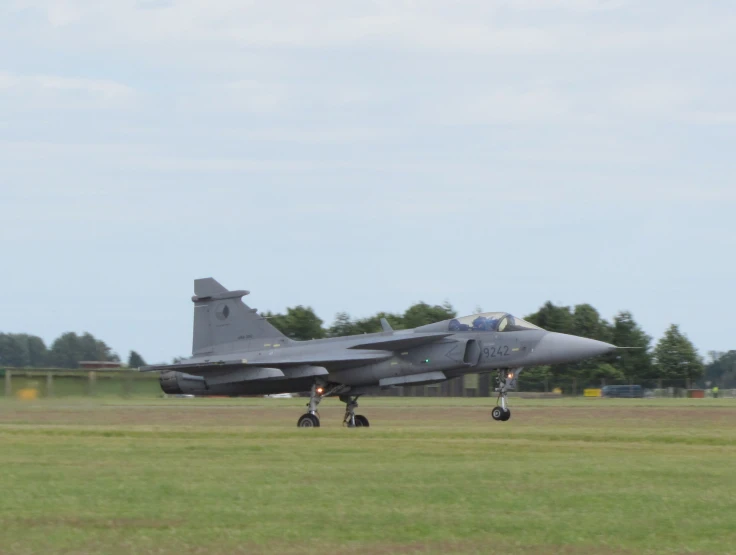 military jet in flight on grassy area near airport