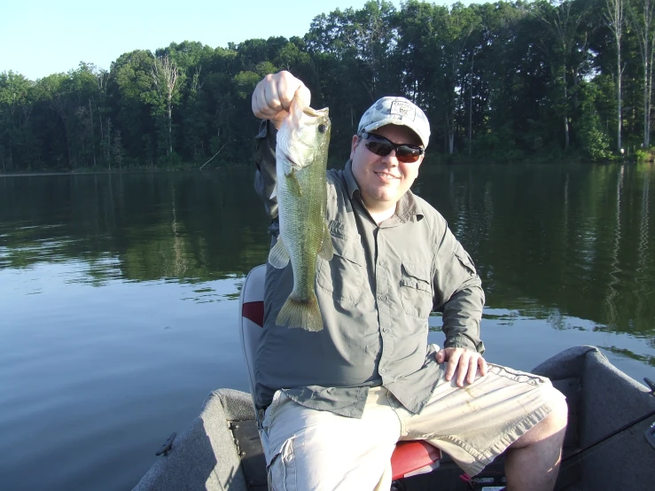 a man on a boat holding a fish