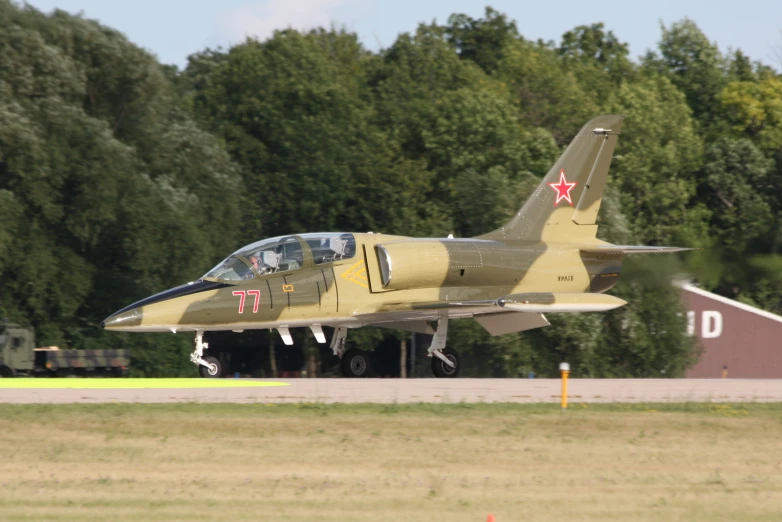 a military jet flying low on an airstrip