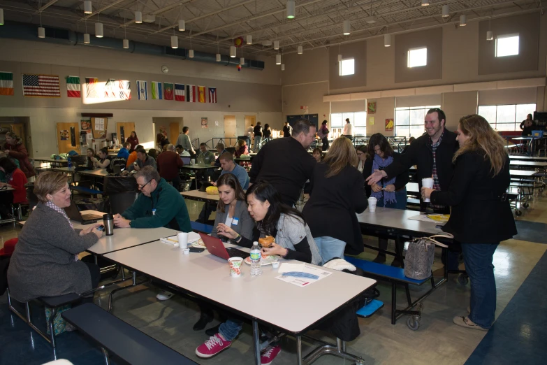 many students sit at tables with a white table