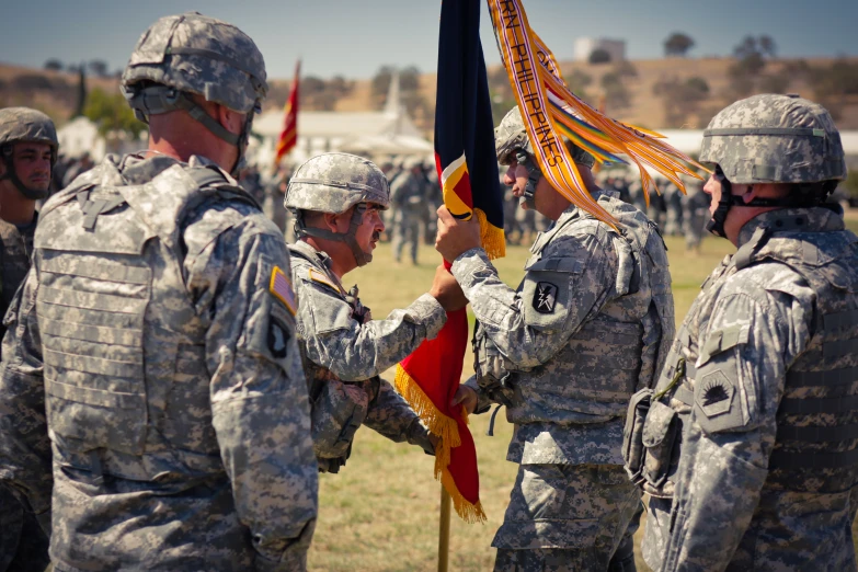 four soldiers in uniform holding flags and talking