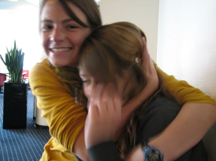 a woman and a child hugging each other in a room