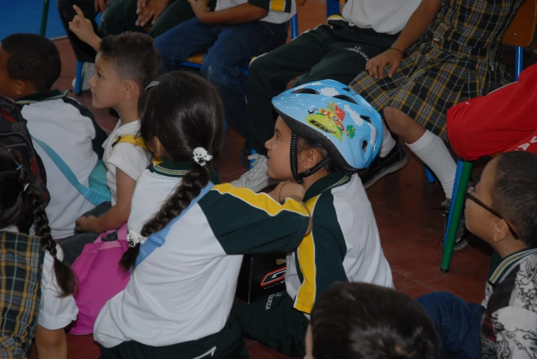 a group of children in school uniforms sit down