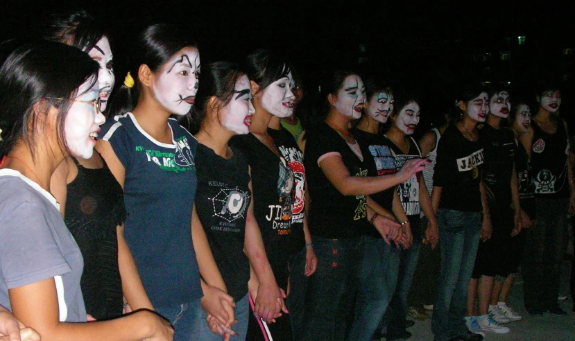 a group of people with their faces painted like makeup