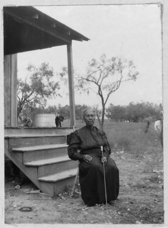 an old picture of a man sitting on a set of stairs outside