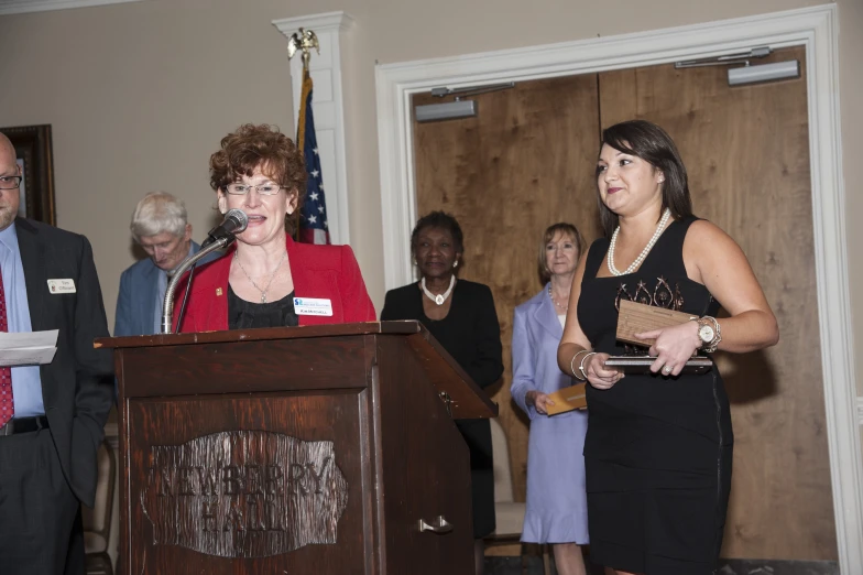 some people standing and standing at a podium