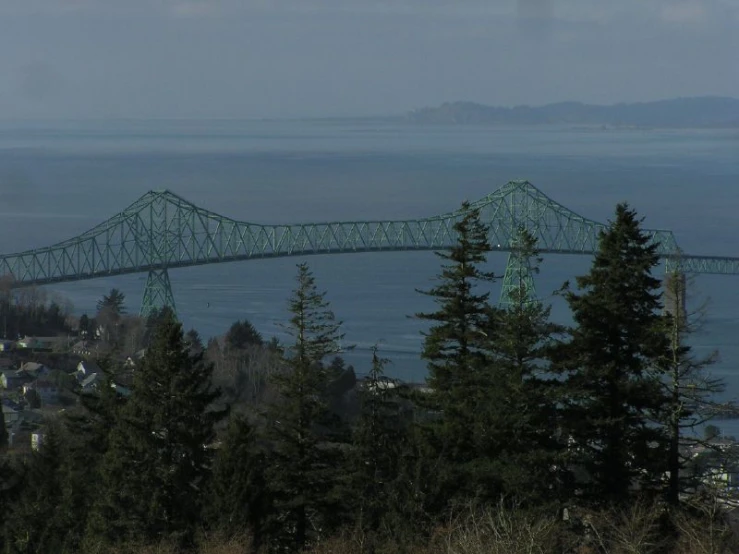 the view from the hill of an ocean and a bridge