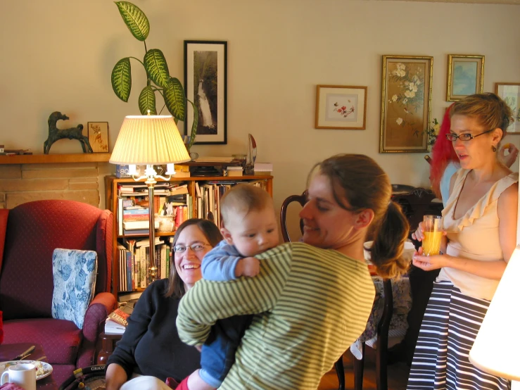 a lady holding a baby and looking at the floor