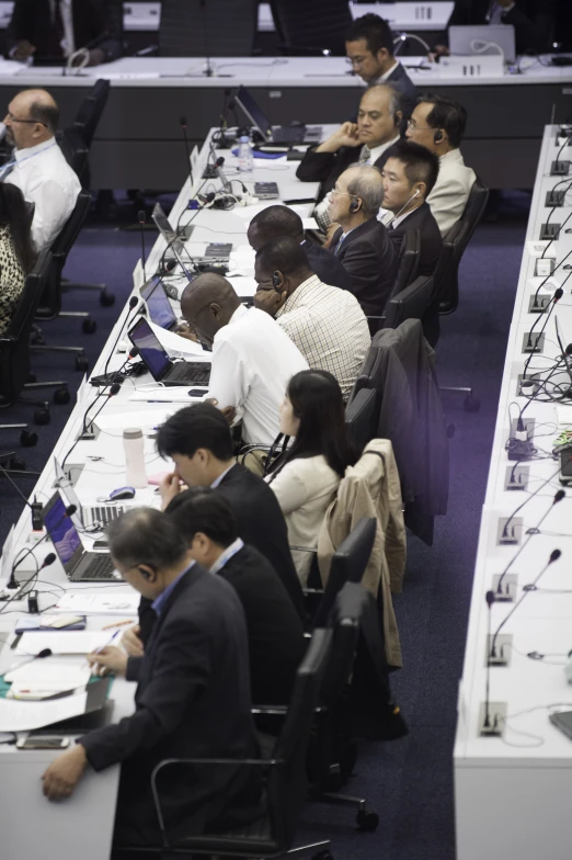 many people sitting at the tables with computers