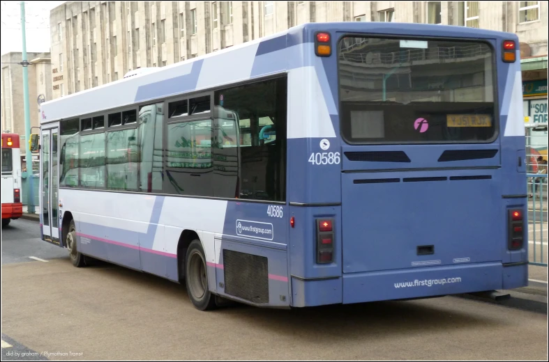 the blue city bus is parked on the street