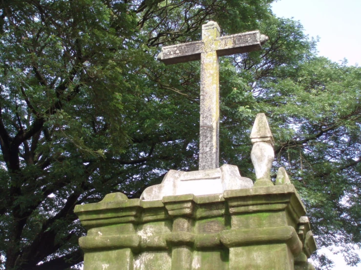 a stone statue in front of some trees