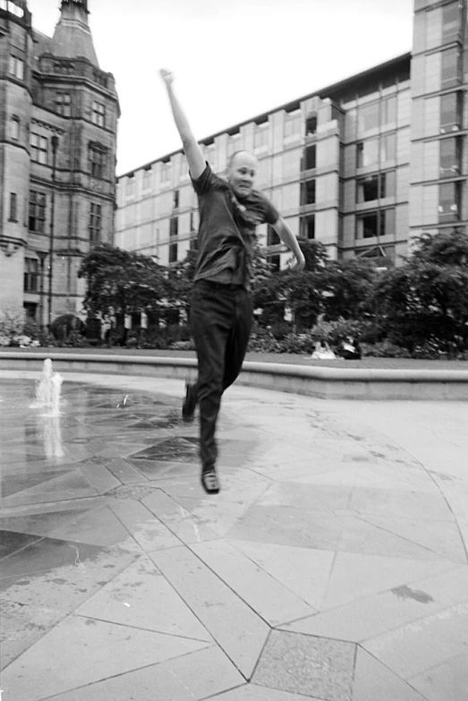 a man jumping in the air above a fountain